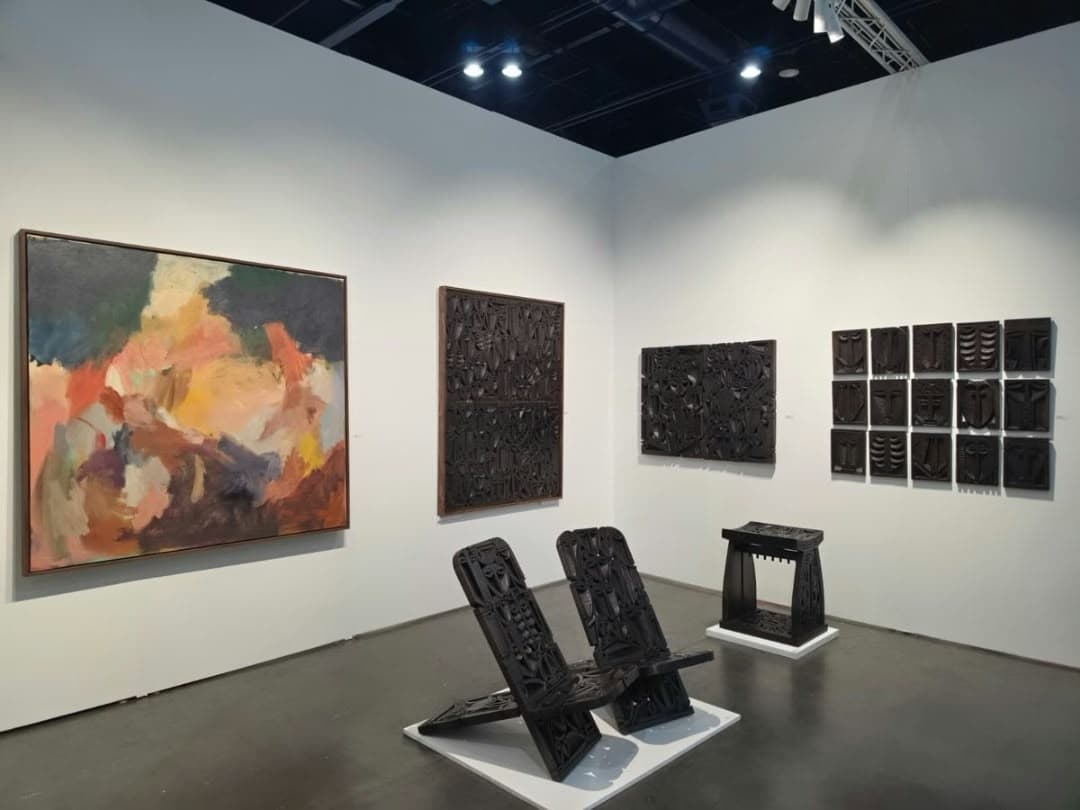 The chairs and the stool on the booth floor, in dialogue with Demetrius Wilson's painting.