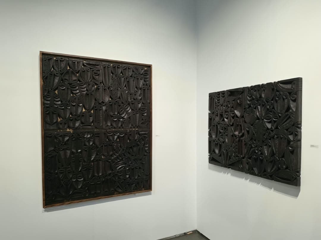 Two large relief panels, carved face over carved face.